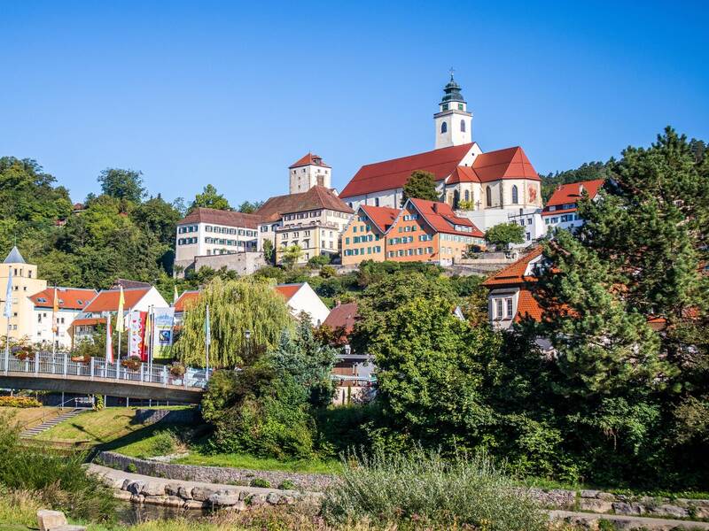 Horb am Neckar mit bunten Gebäuden und einer Kirche auf einem Hügel, umgeben von grüner Landschaft.
