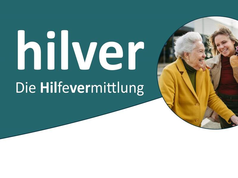 Junge Frau mit Blumen lächelt ältere Frau im gelben Mantel an, Symbol für Hilfsvermittlung von Hilver.