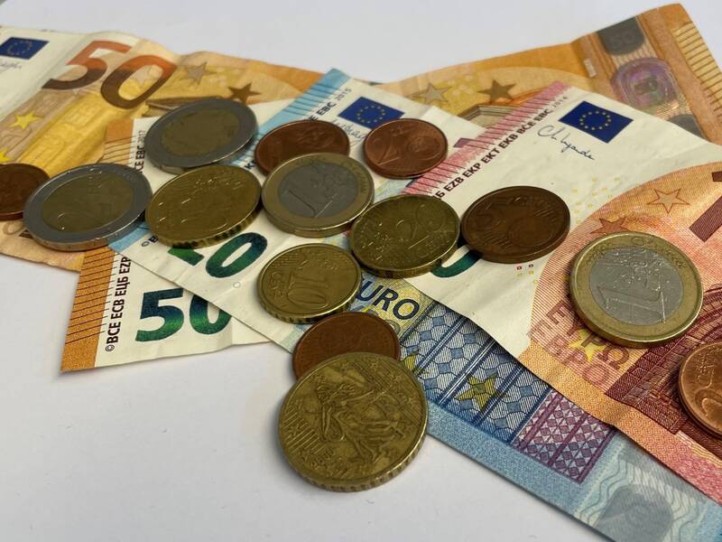 Verschiedene Euro-Banknoten und Münzen, darunter 50, 20 und 10 Euro Scheine, auf weißem Hintergrund.