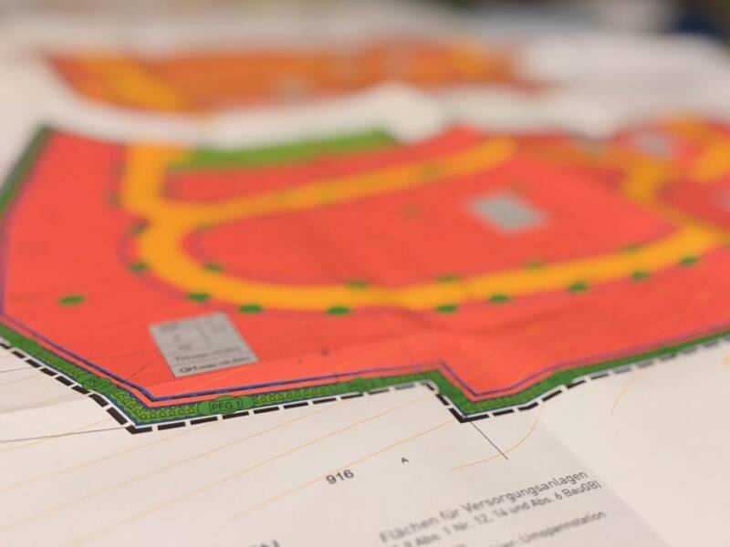 Ein bunter Stadtplan mit Straßen, Gebäude und markierte Bereiche in verschiedenen Farben.