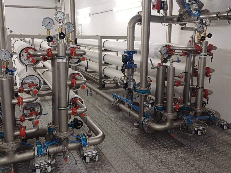 Das Bild zeigt ein komplexes System aus metallischen Rohren und Messgeräten in einem industriellen Umfeld.