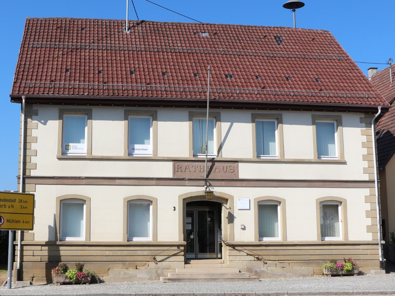 Ein zweistöckiges, historisches Gebäude vor einem tiefblauen Himmel.