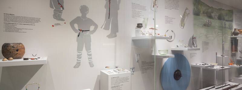 Ein Museum zeigt eine Glasvitrine mit verschiedenen Ausstellungsstücken.