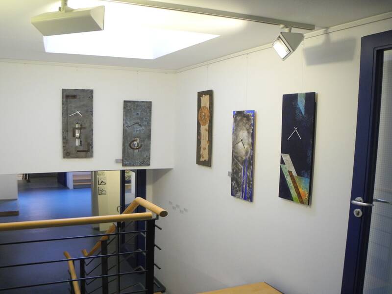 Das Bild zeigt kunstvolle Wanduhren in einem Treppenhaus.