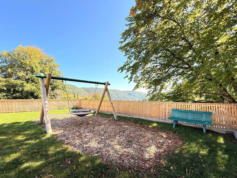Kinderschaukel mit einer Bank unter blauem Himmel