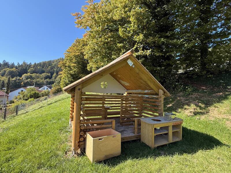 Spielhaus aus Holz unter blauem Himmel