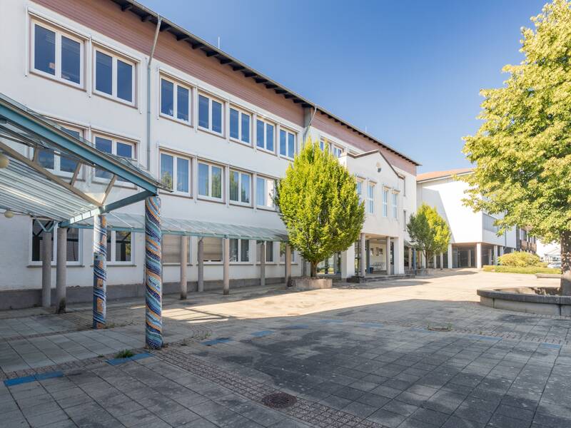 Ein modernes Gebäude mit weißen Wänden und vielen Fenstern.