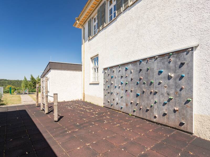 Das Bild zeigt ein Klettergerüst hinter einer Schule.