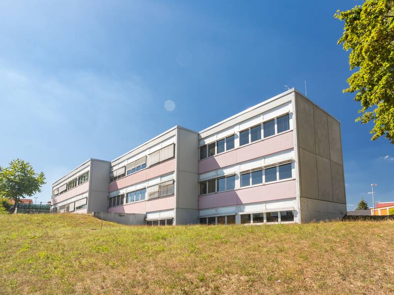Ein modernes Gebäude mit weißen Wänden und vielen Fenstern.