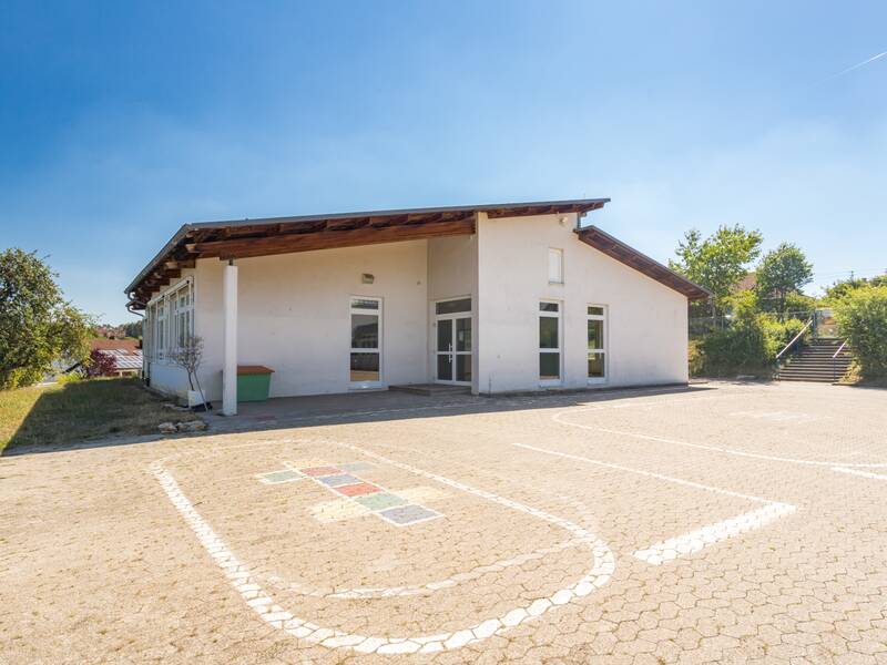 Das Bild zeigt den Schulhof unter einem blauen Himmel.