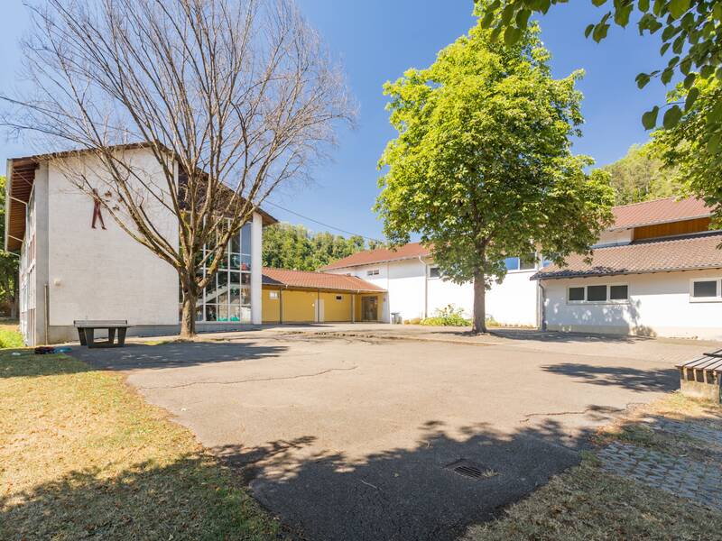 Das Bild zeigt den Schulhof unter einem blauen Himmel.