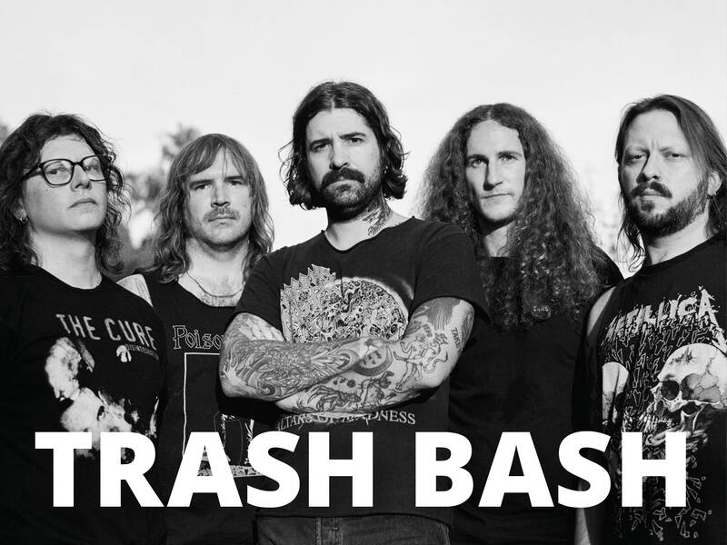 Eine Gruppe von fünf Personen mit T-Shirts von Rockbands posiert mit ernstem Gesichtsausdruck; der Text "TRASH BASH" steht im Vordergrund.