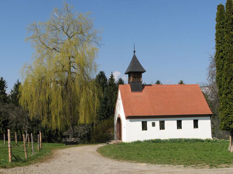 Eine Kapelle in ländlicher Landschaft und einem blauen Himmel