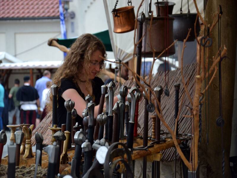 Eine Frau die Schwerter auf dem Mittelaltermarkt der Ritterspiele verkauft